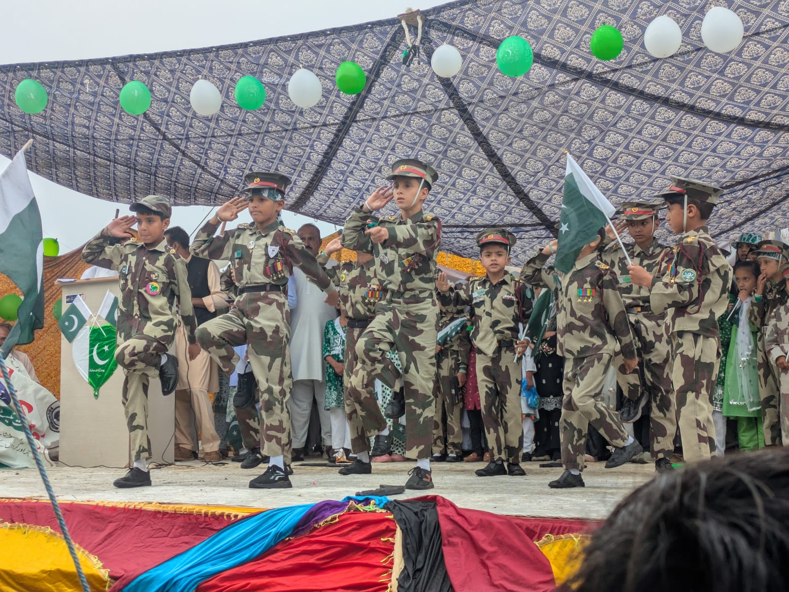 Kids in scout uniforms marching and saluting